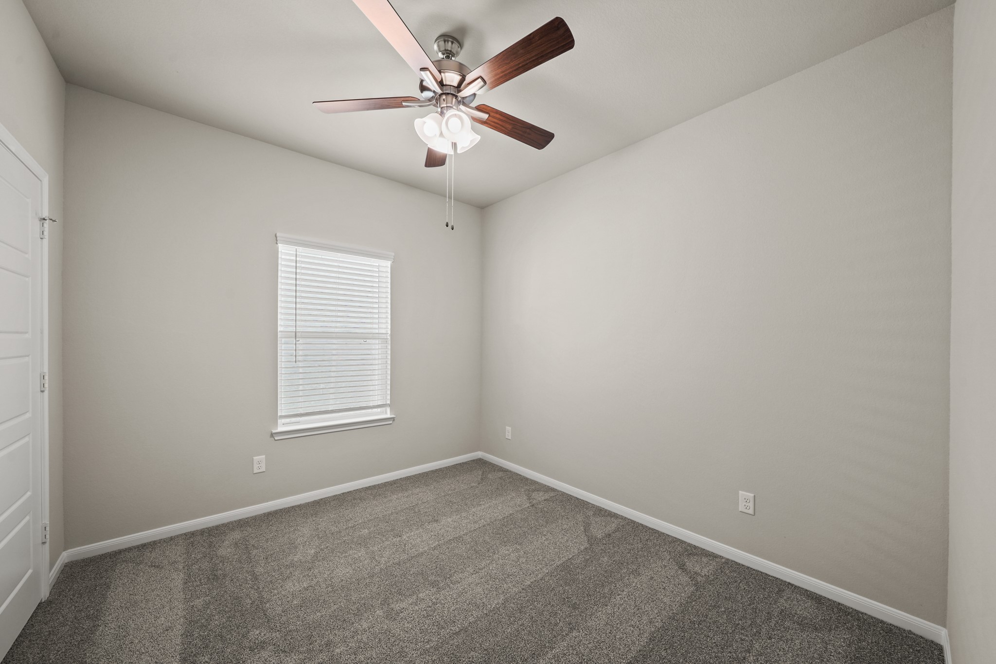 15025 Alkay Street Houston, TX 77053 - Photo 8 of 11 an empty room with a chandelier fan and windows