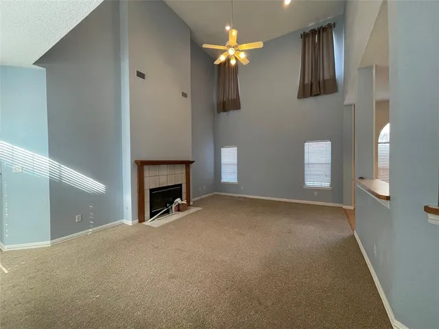 a view of a livingroom with a fireplace and a chandelier fan