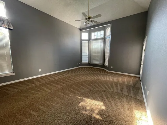 en empty room with windows and ceiling fan view