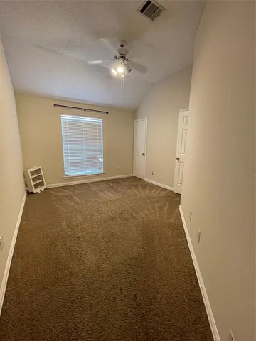 an empty room with a ceiling fan and a window
