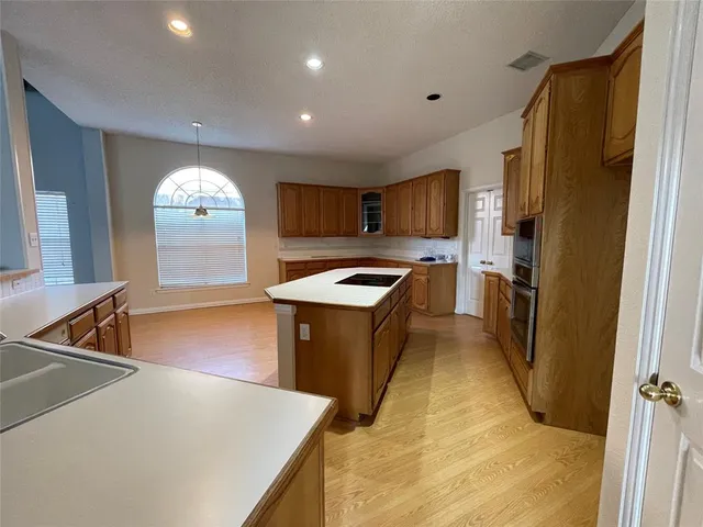 a kitchen with granite countertop a refrigerator stove top oven and sink