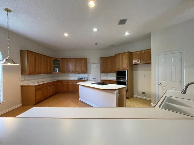 a large white kitchen with a stove a sink a microwave and a refrigerator
