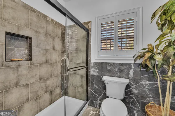 a bathroom with a toilet and a shower