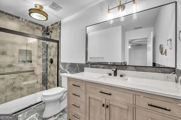 a bathroom with a sink a toilet and shower