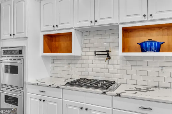 a kitchen with granite countertop white cabinets and white appliances