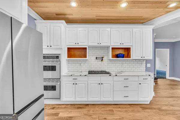 a kitchen with stainless steel appliances white cabinets and a refrigerator