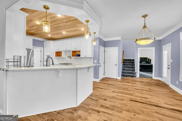 a kitchen with kitchen island granite countertop a sink a stove and cabinets