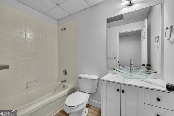 a bathroom with a granite countertop sink toilet and shower