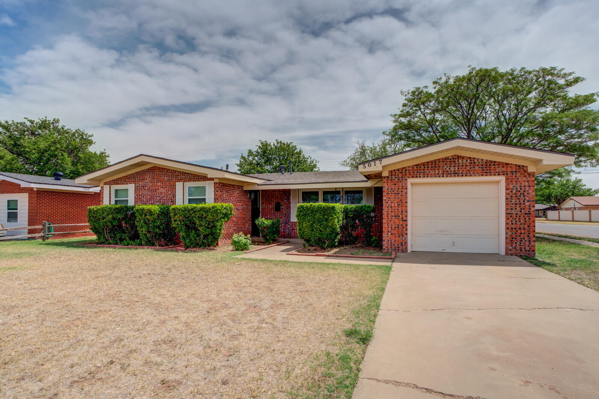 5017 46th Street Lubbock, TX 79414 - Photo 1 of 32 a front view of a house with a yard and a garage