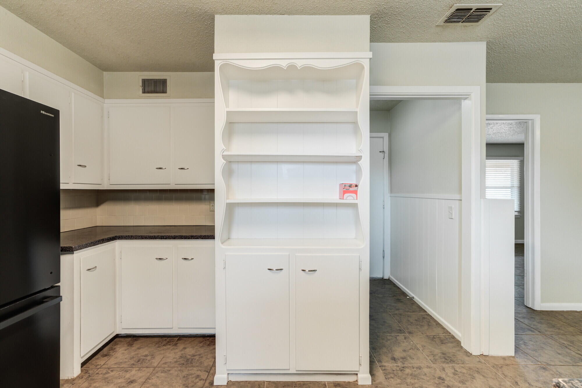 5017 46th Street Lubbock, TX 79414 - Photo 14 of 32 a kitchen with white cabinets and a refrigerator
