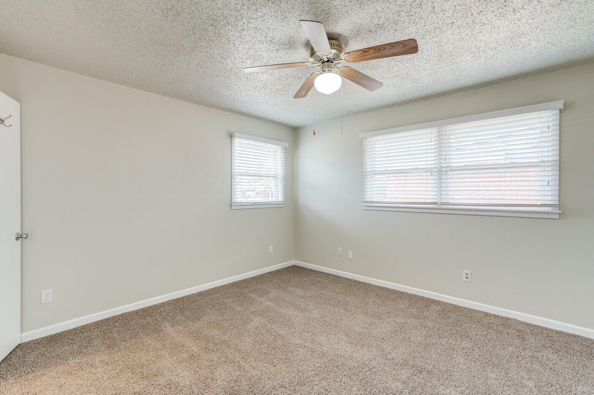 5017 46th Street Lubbock, TX 79414 - Photo 17 of 32 an empty room with windows and fan