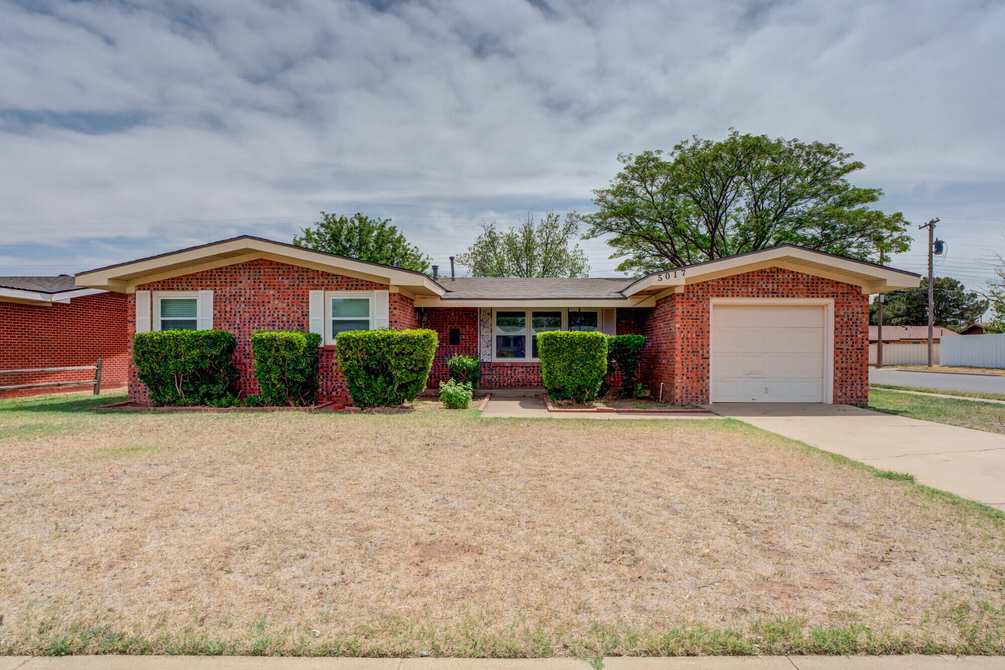 5017 46th Street Lubbock, TX 79414 - Photo 2 of 32 a front view of house with yard and trees around
