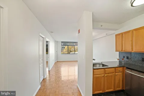 a hallway with cabinets and wooden floor
