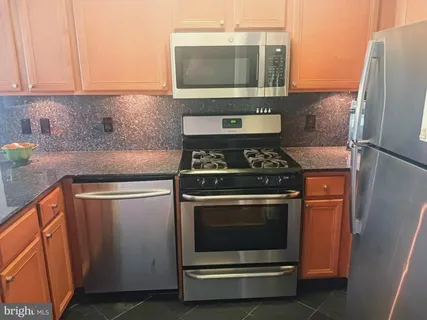 a kitchen with stainless steel appliances wooden cabinets and stove