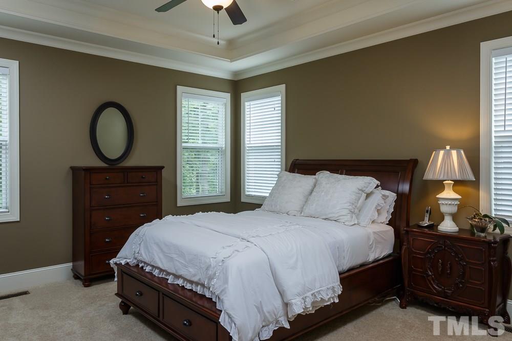 3429 Griffice Mill Road Raleigh, NC 27610 - Photo 13 of 25 a bedroom with a bed and a mirror