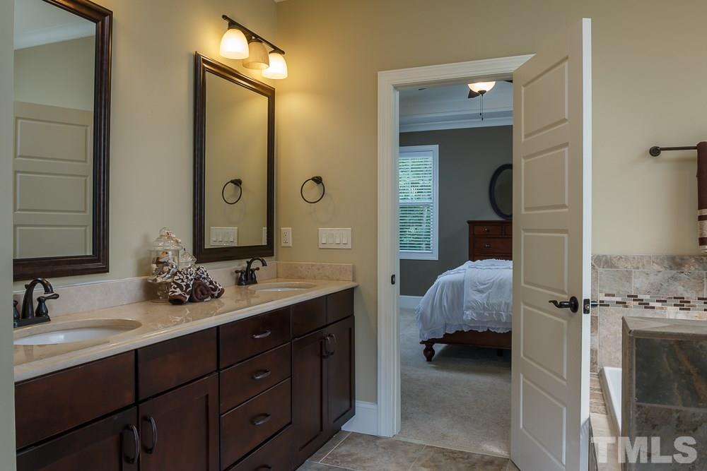 3429 Griffice Mill Road Raleigh, NC 27610 - Photo 14 of 25 a en suite bathroom with a double vanity sink a mirror and a shower