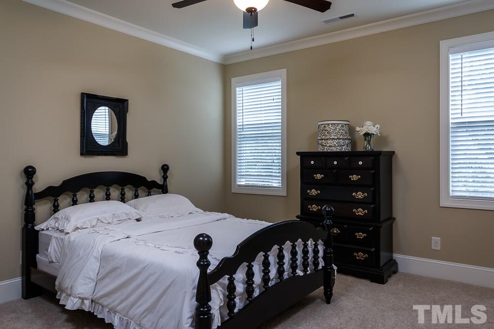 3429 Griffice Mill Road Raleigh, NC 27610 - Photo 16 of 25 a bedroom with a bed a window and a lamp