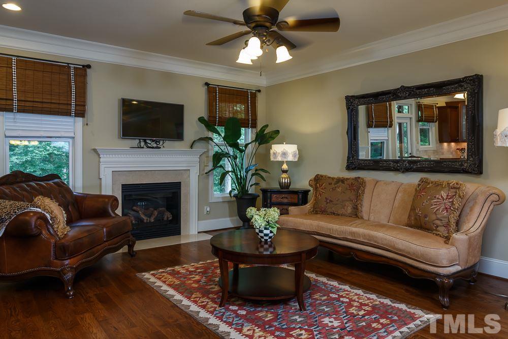 3429 Griffice Mill Road Raleigh, NC 27610 - Photo 8 of 25 a living room with furniture a fireplace and a flat screen tv