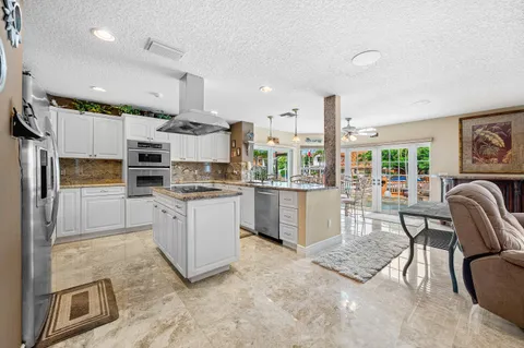 a living room with furniture kitchen view and a window