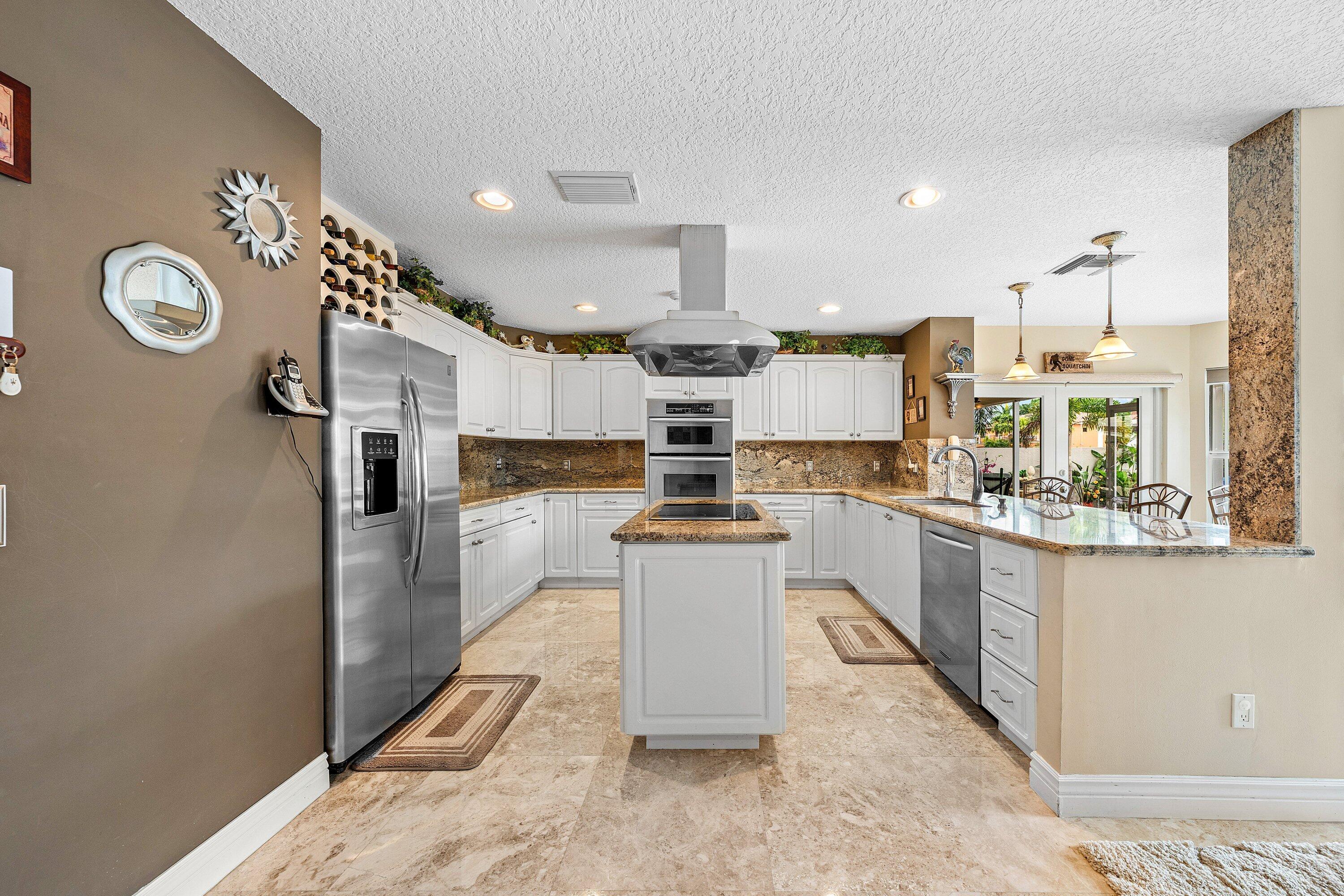 1548 Southwest 5th Avenue Boca Raton, FL 33432 - Photo 16 of 64 a kitchen with stainless steel appliances granite countertop a refrigerator a oven and white cabinets