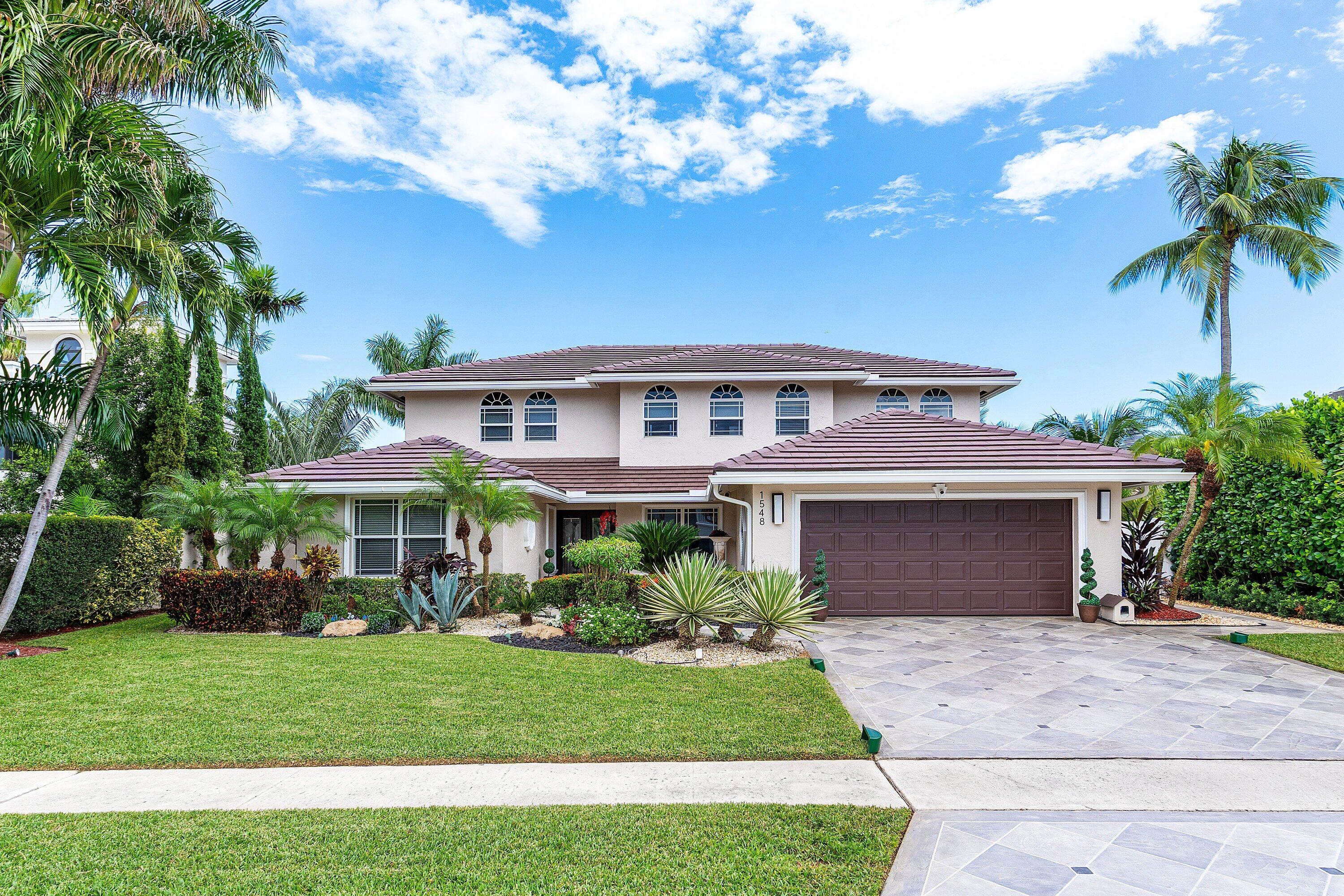 1548 Southwest 5th Avenue Boca Raton, FL 33432 - Photo 5 of 64 a front view of a house with a garden and trees
