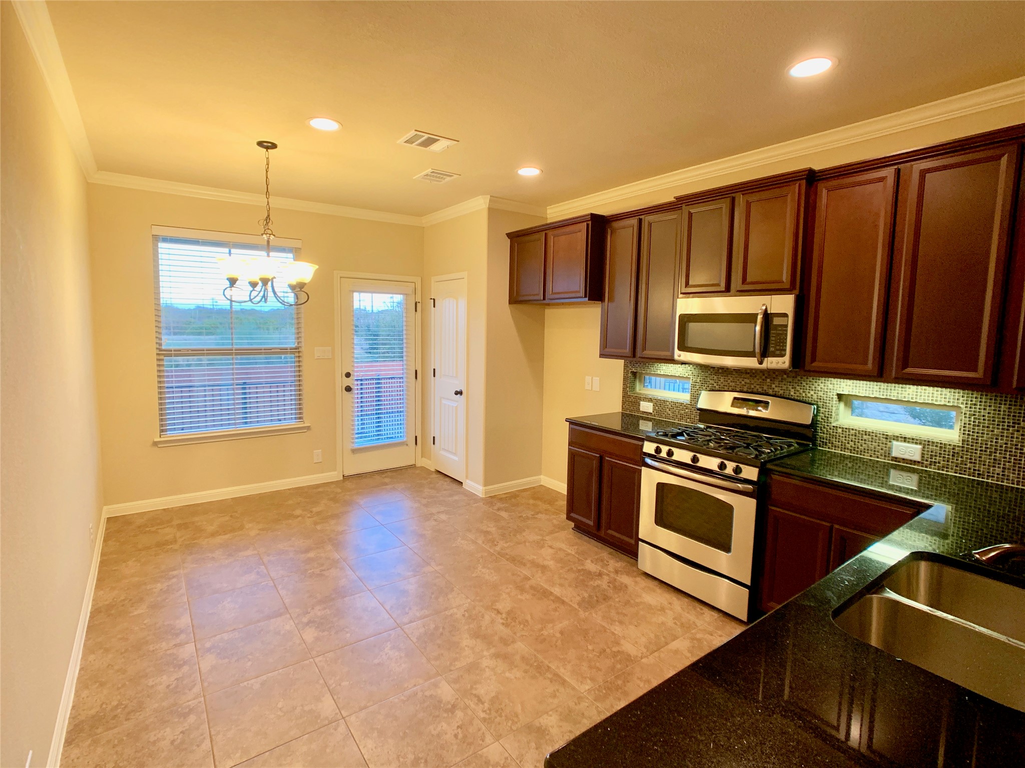 14001 Avery Ranch Boulevard, Unit 1204 Austin, TX 78717 - Photo 4 of 18 a kitchen with stainless steel appliances granite countertop a stove a sink and a refrigerator