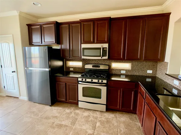 a kitchen with granite countertop wooden cabinets and stainless steel appliances