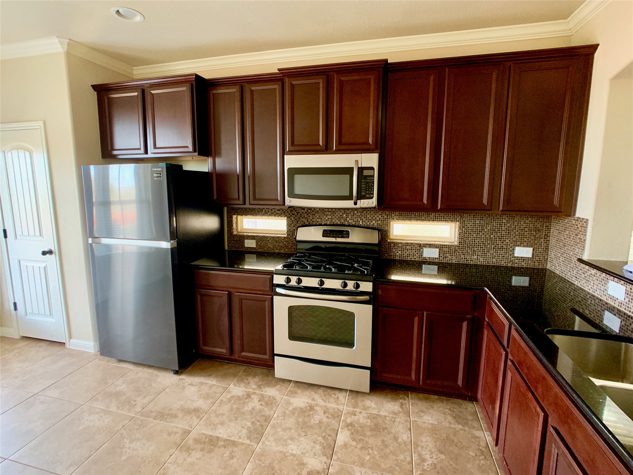 14001 Avery Ranch Boulevard, Unit 1204 Austin, TX 78717 - Photo 5 of 18 a kitchen with granite countertop wooden cabinets and stainless steel appliances