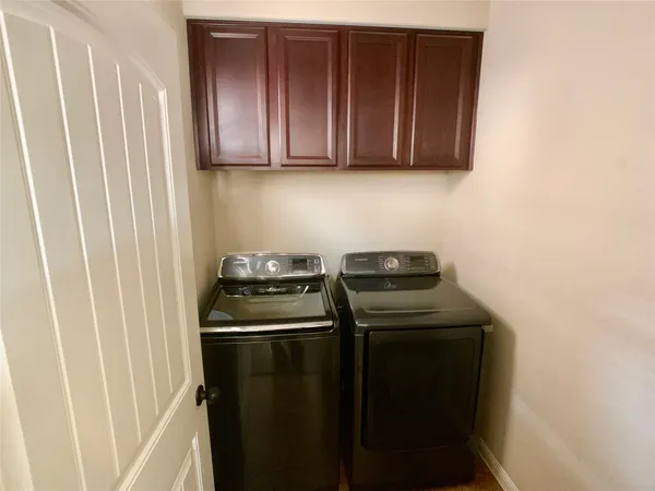 a view of a kitchen with stainless steel appliances wooden floor washer and dryer
