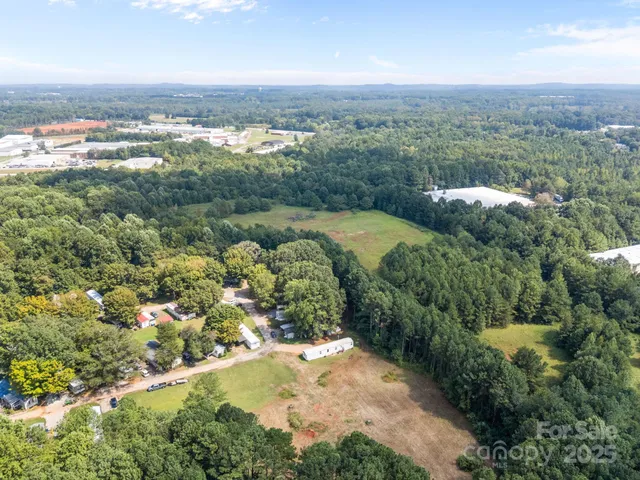 an aerial view of residential houses with outdoor space and trees