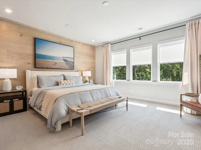 a bed sitting in a spacious bedroom next to a window