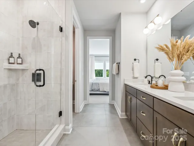 a spacious bathroom with a double vanity sink a mirror and shower