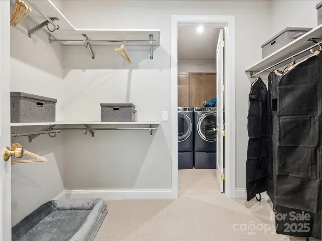 a view of walk in closet with clothes and shoes