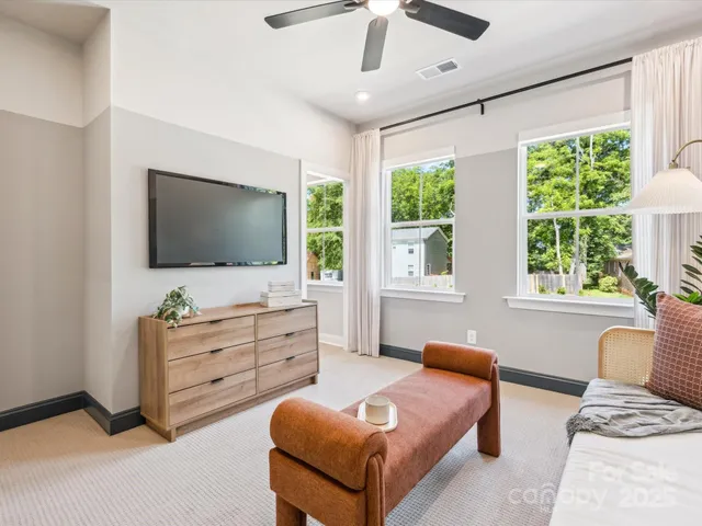 a bedroom with furniture and a flat screen tv