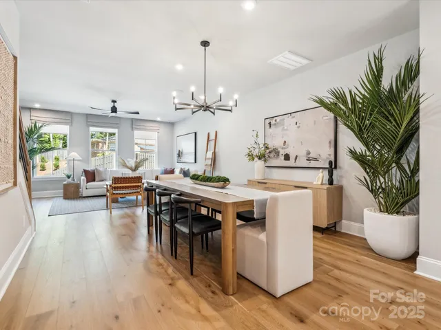 a living room with a table chairs and a potted plant