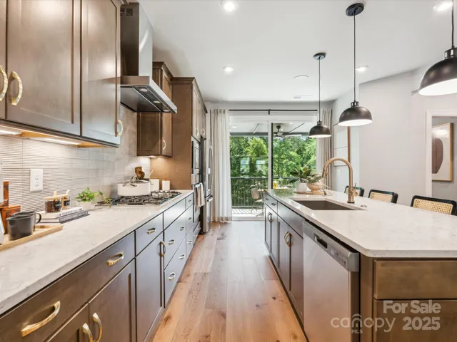 a kitchen with stainless steel appliances granite countertop a sink a stove and a refrigerator