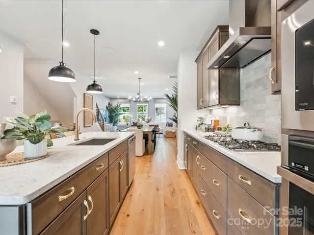 a kitchen with stainless steel appliances kitchen island granite countertop a sink stove and cabinets