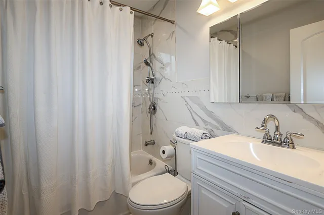 a bathroom with a sink a toilet and shower curtain