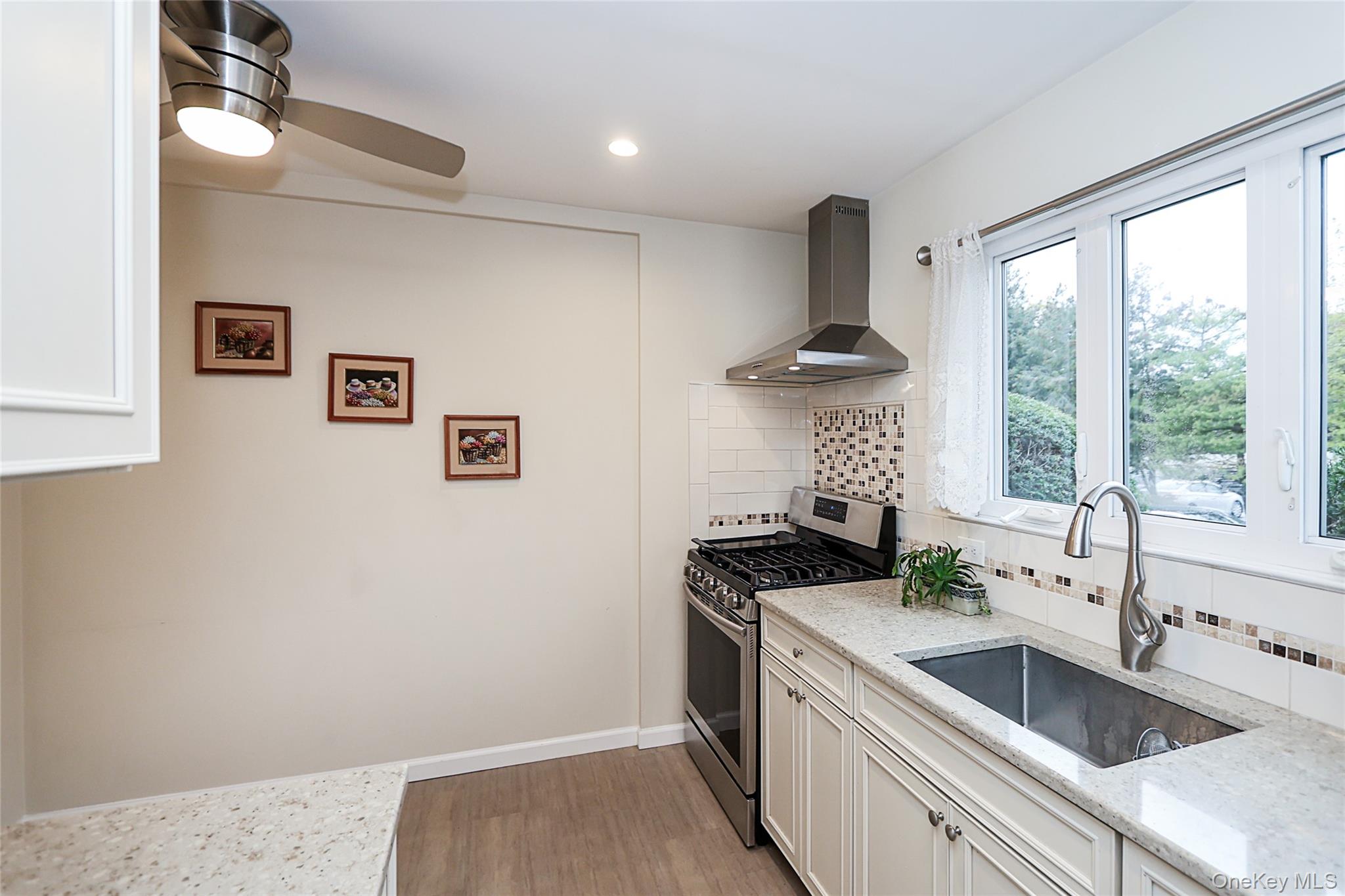 6 Gerhard Road Plainview, NY 11803 - Photo 3 of 29 a kitchen with a stove a sink and a refrigerator