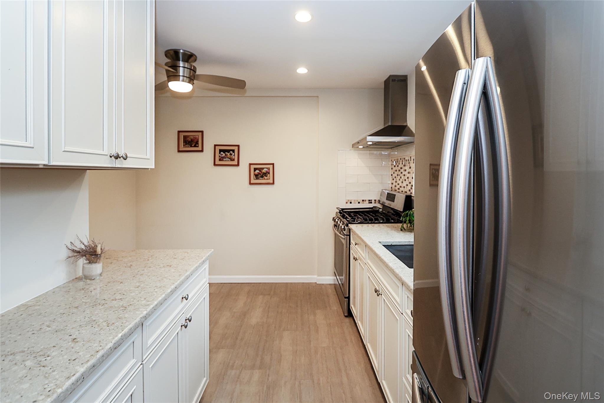 6 Gerhard Road Plainview, NY 11803 - Photo 5 of 29 a kitchen with a sink a refrigerator and cabinets
