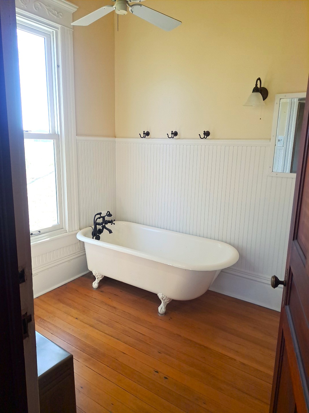 105 Davis Drive Thorndale, TX 76577 - Photo 16 of 21 Rich hardwood flooring pairs with classic beadboard paneling and an elegant clawfoot tub.