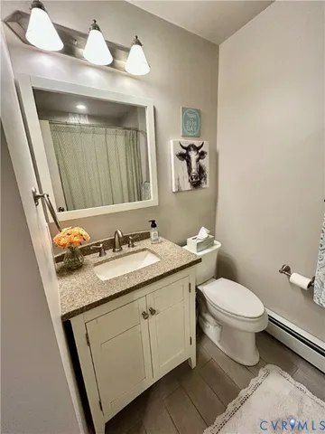 a bathroom with a granite countertop toilet sink and mirror