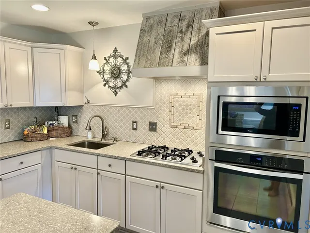 a kitchen with stainless steel appliances a stove a sink and cabinets
