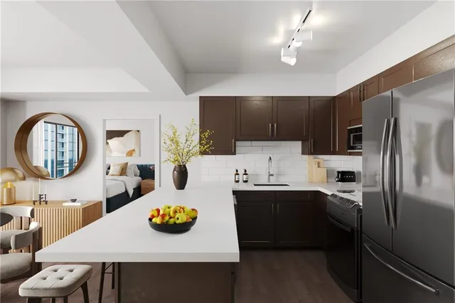a kitchen with stainless steel appliances a table chairs and a refrigerator