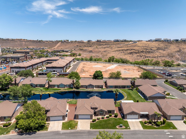 805 South River Road, Unit 70 St. George, UT 84790 - Photo 34 of 38 Residential community featuring a prominent water feature, single-story homes with tile roofs, and manicured landscaping