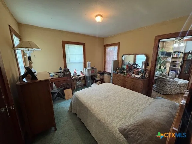 a bed room with a bed window and dresser