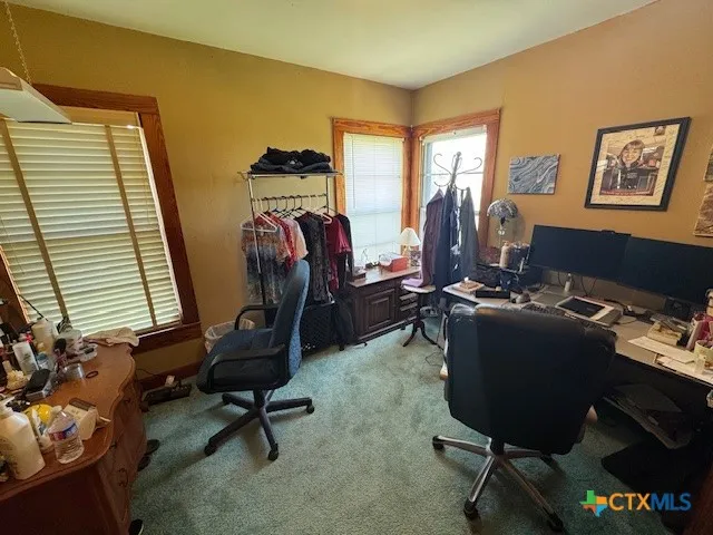 a view of a workspace with furniture and a window