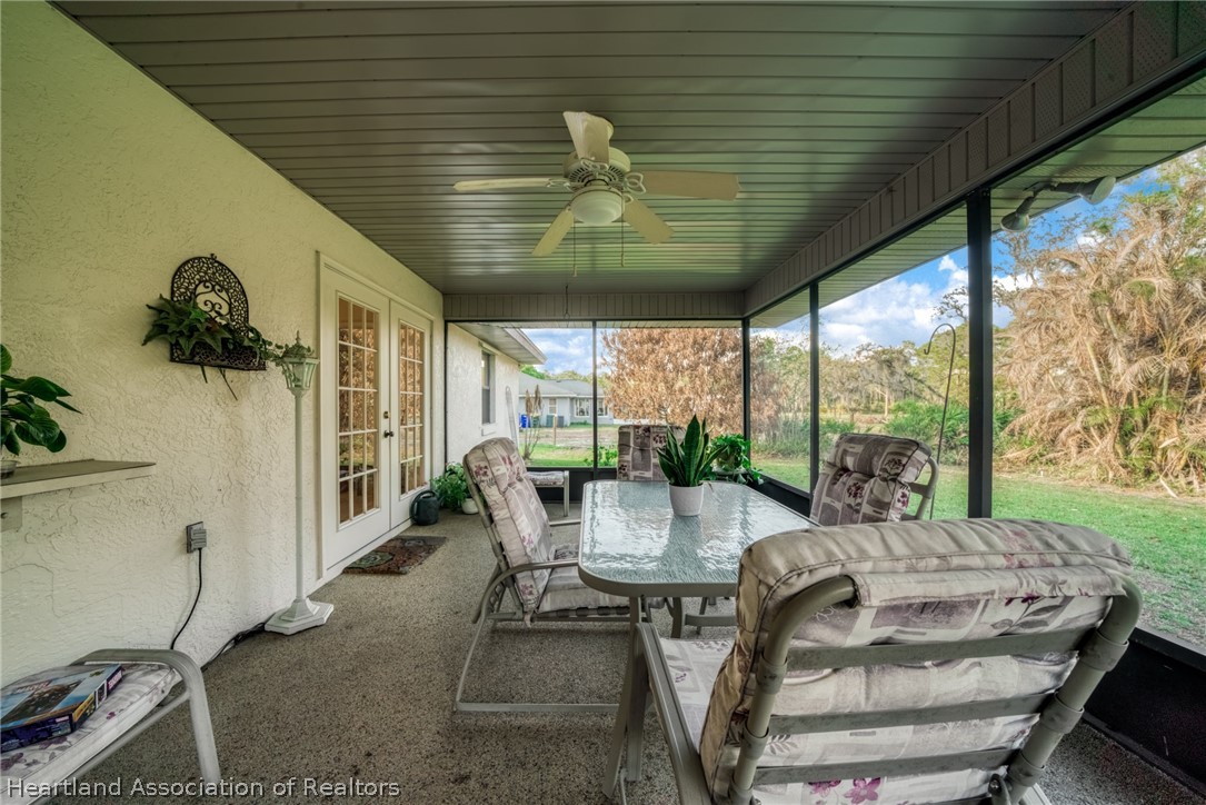5802 Golden Road Sebring, FL 33875 - Photo 27 of 37 a view of a patio with table and chairs potted plants with floor to ceiling window