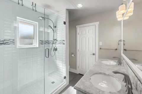 a bathroom with a granite countertop sink a toilet and shower