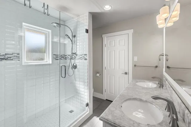 a bathroom with a granite countertop sink a toilet and shower